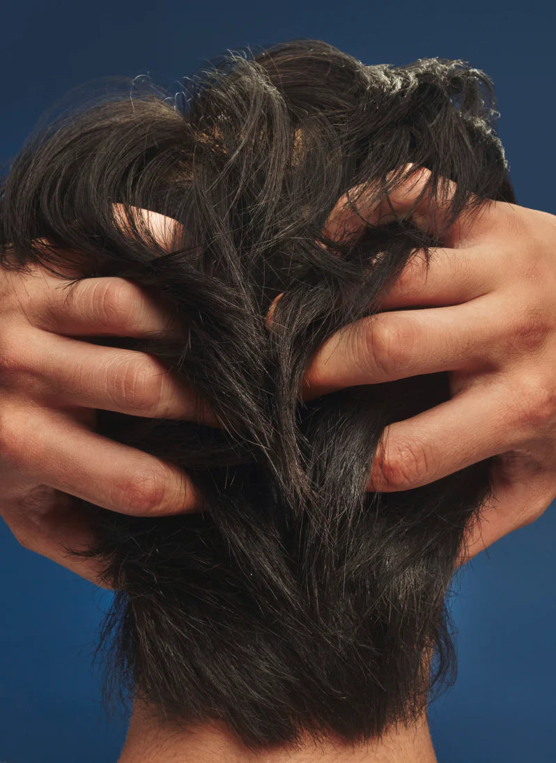 Man running hands through thick healthy hair